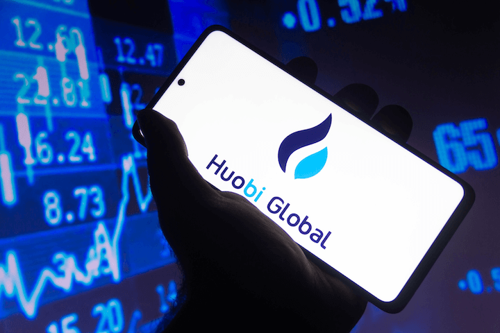 A person holding their phone with the Huobi app running