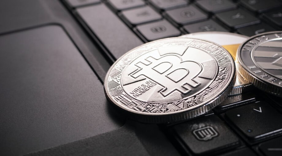 Silver crypto coins lying on the laptop keyboard