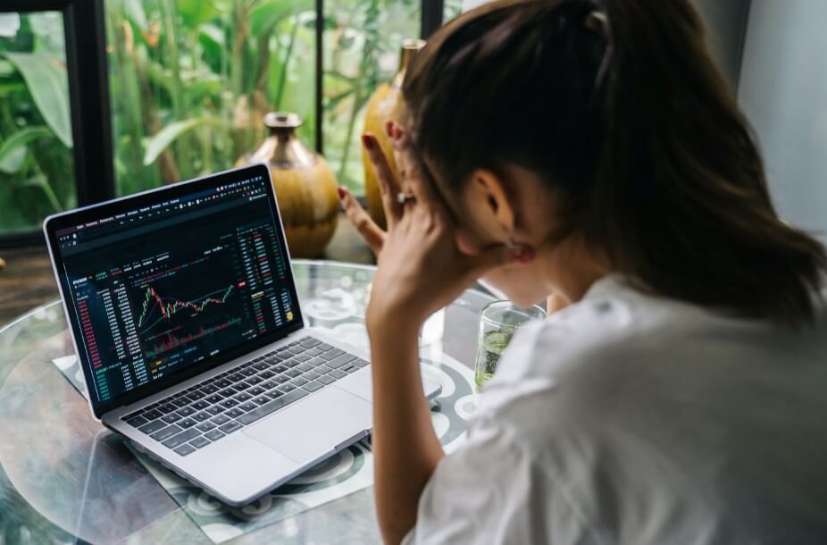 A woman looking at cryptocurrency charts on her laptop