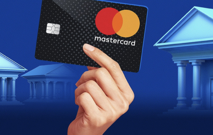 A bank card in the person's hand on a blue background