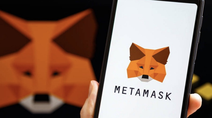 A person holding a phone with a MetaMask cryptocurrency wallet